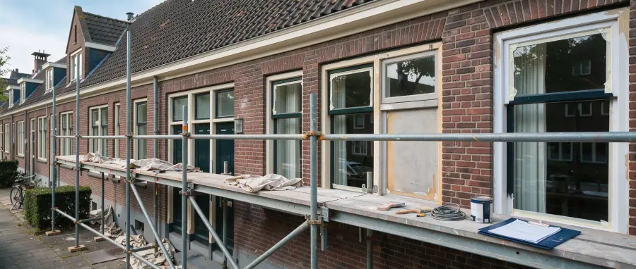 Arnhems appartementencomplex met steiger langs geschilderde houten kozijnen en een inspectiemap op de voorgrond
