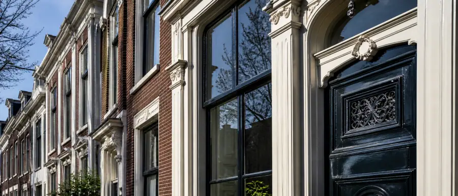 Straat met hoge negentiende-eeuwse herenhuizen van drie lagen, met sierlijke kroonlijsten en bakstenen gevels